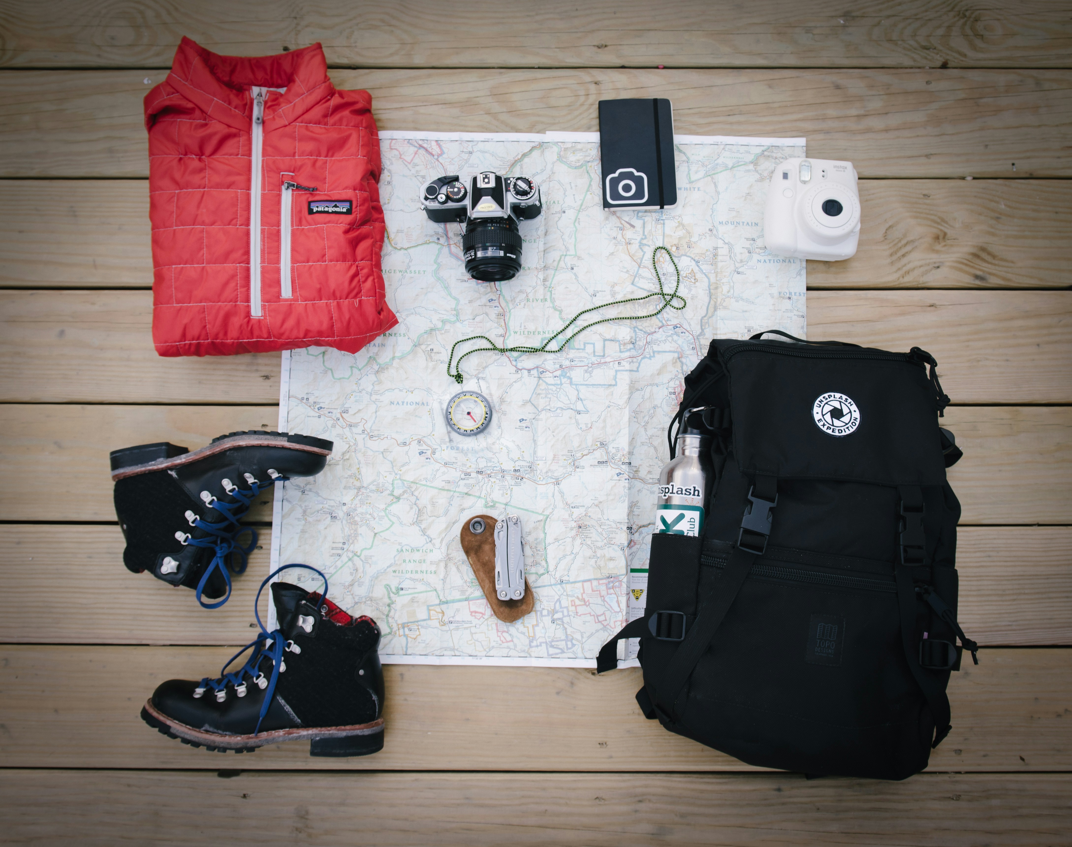 A backpack, hiking boots, and a camera arranged on a map, symbolizing adventure for family holiday packages in Kenya.